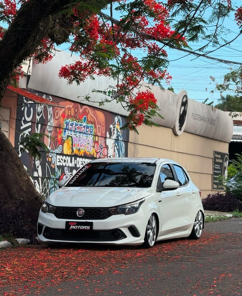 Fiat Argo branco rebaixado com fundo de grafite colorido e paisagismo