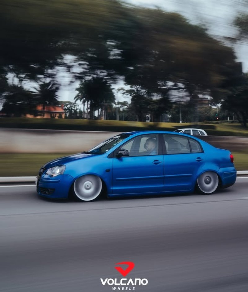 Polo Sedan azul rebaixado andando com rodas lisas
