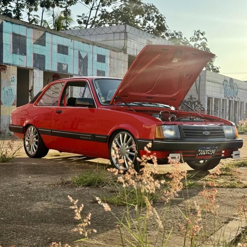 Chevette SL vermelho em ângulo lateral com rodas esportivas