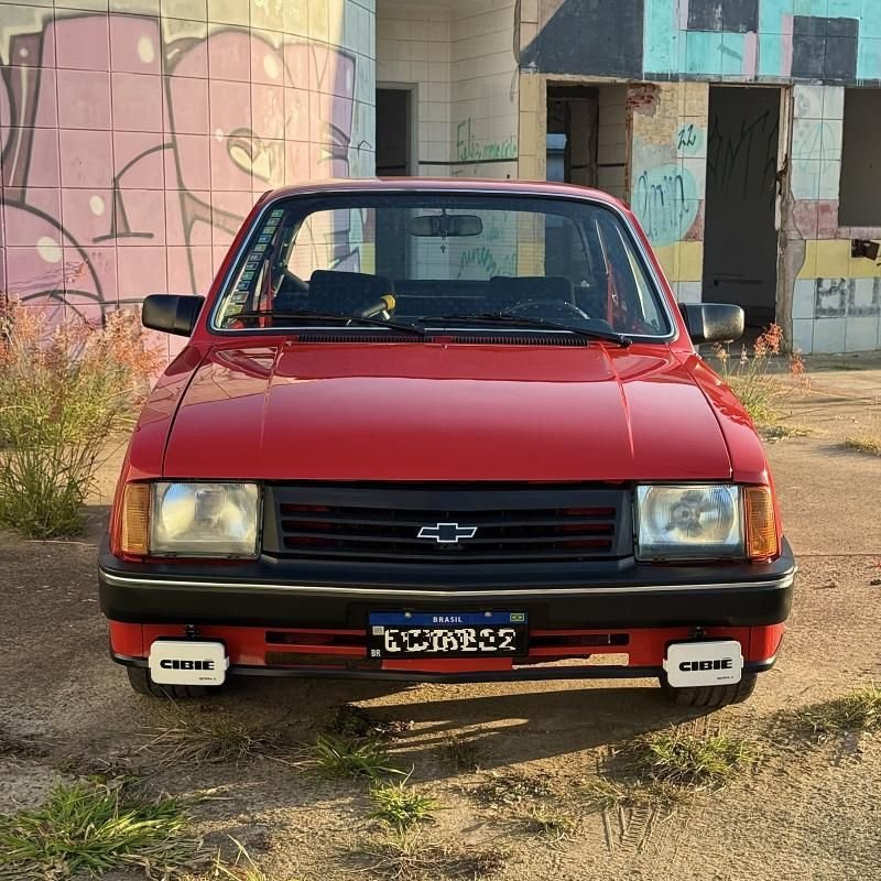 Chevette SL vermelho visto de frente com faróis de milha Cibié