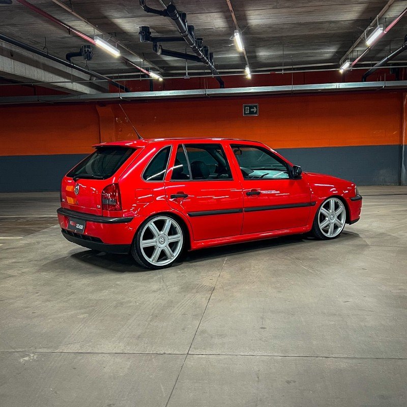 Gol G3 rebaixado com rodas grandes visto de lado em garagem