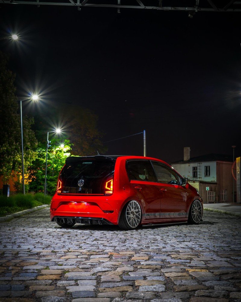 VW Up vermelho com suspensão baixa e rodas grandes