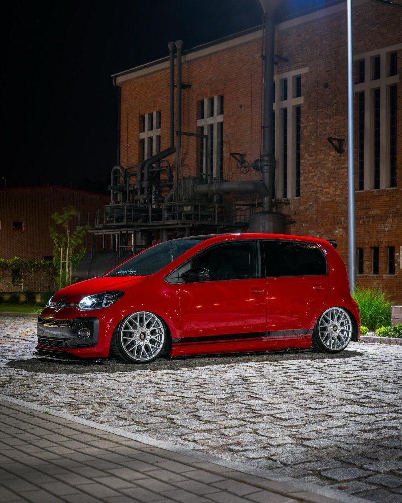VW Up vermelho rebaixado perfil lateral noturno