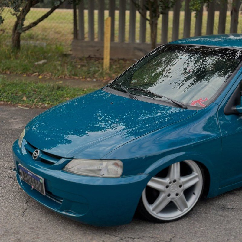 Chevrolet Celta 1.0 verde Atlântida rebaixado com rodas aro 17, vista 3/4 dianteira