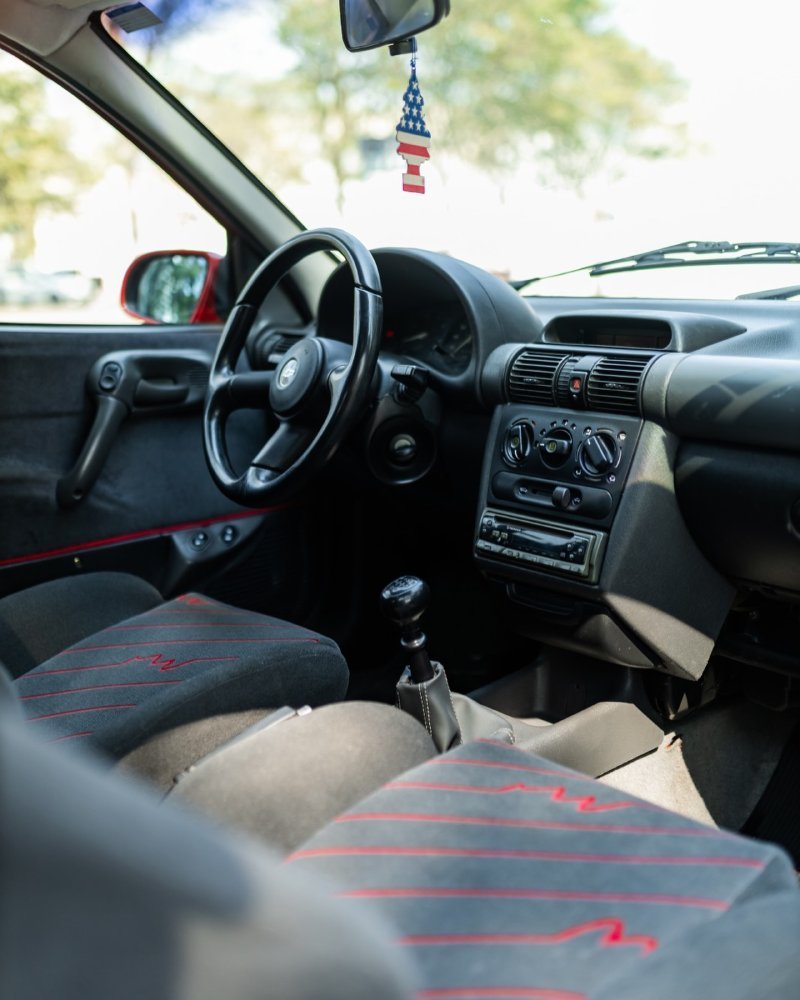 Interior original do Chevrolet Corsa GSi 1995 com bancos esportivos e detalhes vermelhos