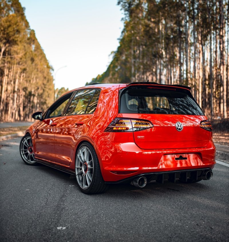 Volkswagen Golf GTI vermelho rebaixado com rodas OZ 19, vista traseira 3/4