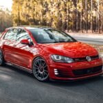 Volkswagen Golf GTI vermelho rebaixado com rodas OZ Racing aro 19 em via urbana