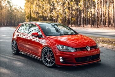 Volkswagen Golf GTI vermelho rebaixado com rodas OZ Racing aro 19 em via urbana