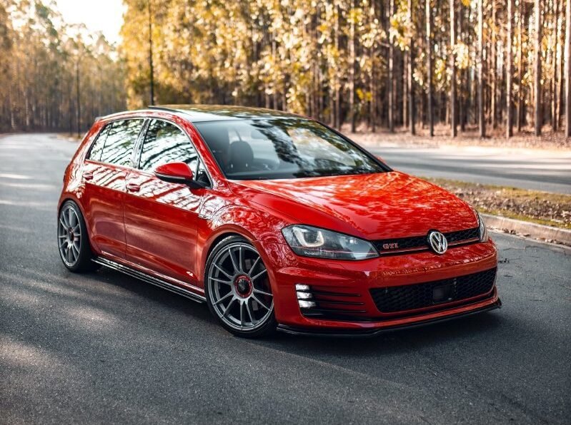 Volkswagen Golf GTI vermelho rebaixado com rodas OZ Racing aro 19 em via urbana
