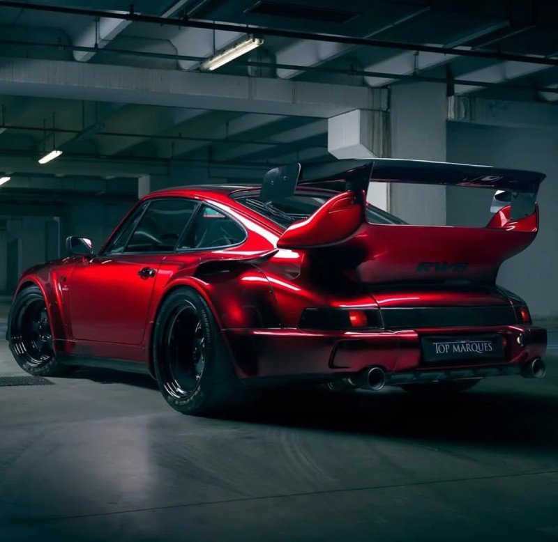 Traseira do Porsche 964 RWB com asa gigante e difusor; placas Top Marques