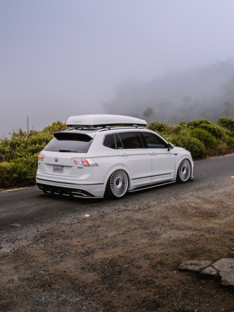 VW Tiguan rebaixada em três-quartos traseiro rodando em estrada