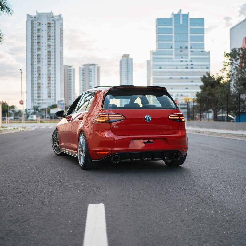 Volkswagen Golf GTI vermelho rebaixado visto por trás em avenida