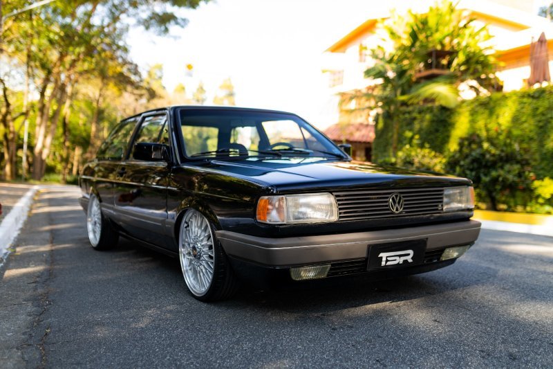 VW Voyage Sport 1994 preto rebaixado com rodas aro 18, ângulo de frente (três-quartos) em via urbana.
