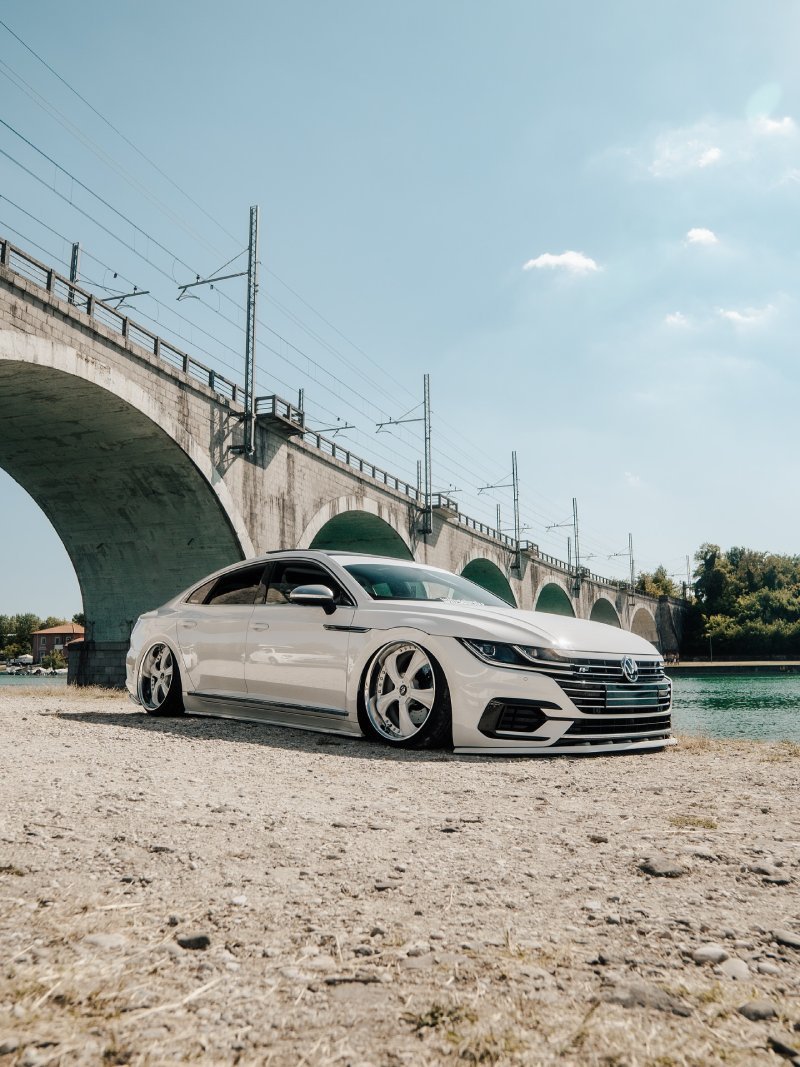 Volkswagen Arteon rebaixado branco Volkswagen Arteon branco rebaixado perfil baixo em local com ponte ao fundo