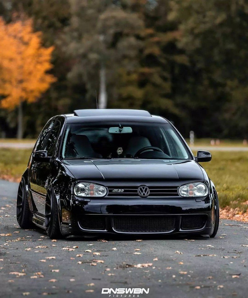 VW Golf R32 Mk4 preto rebaixado — frente baixa sob árvores