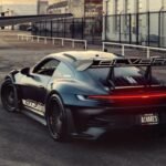 Porsche 992 GT3 RS preto fosco rebaixado com rodas Vossen em cenário de aeroporto