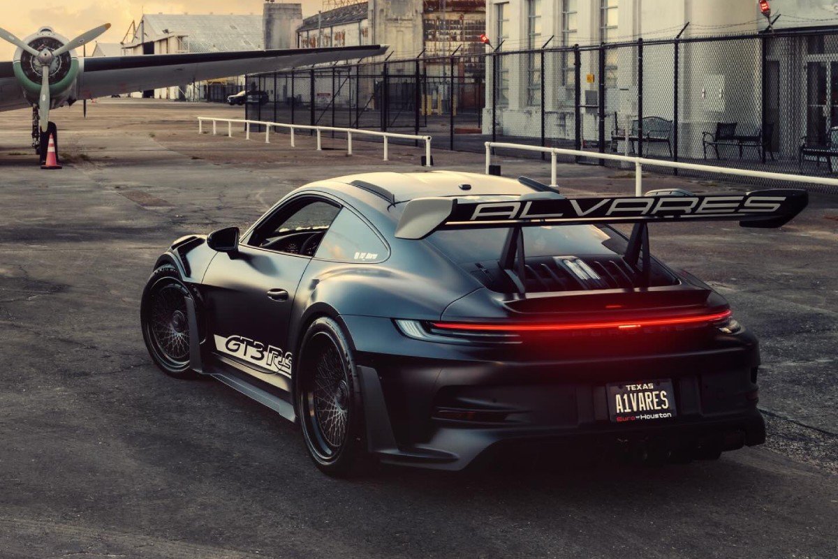 Porsche 992 GT3 RS preto fosco rebaixado com rodas Vossen em cenário de aeroporto