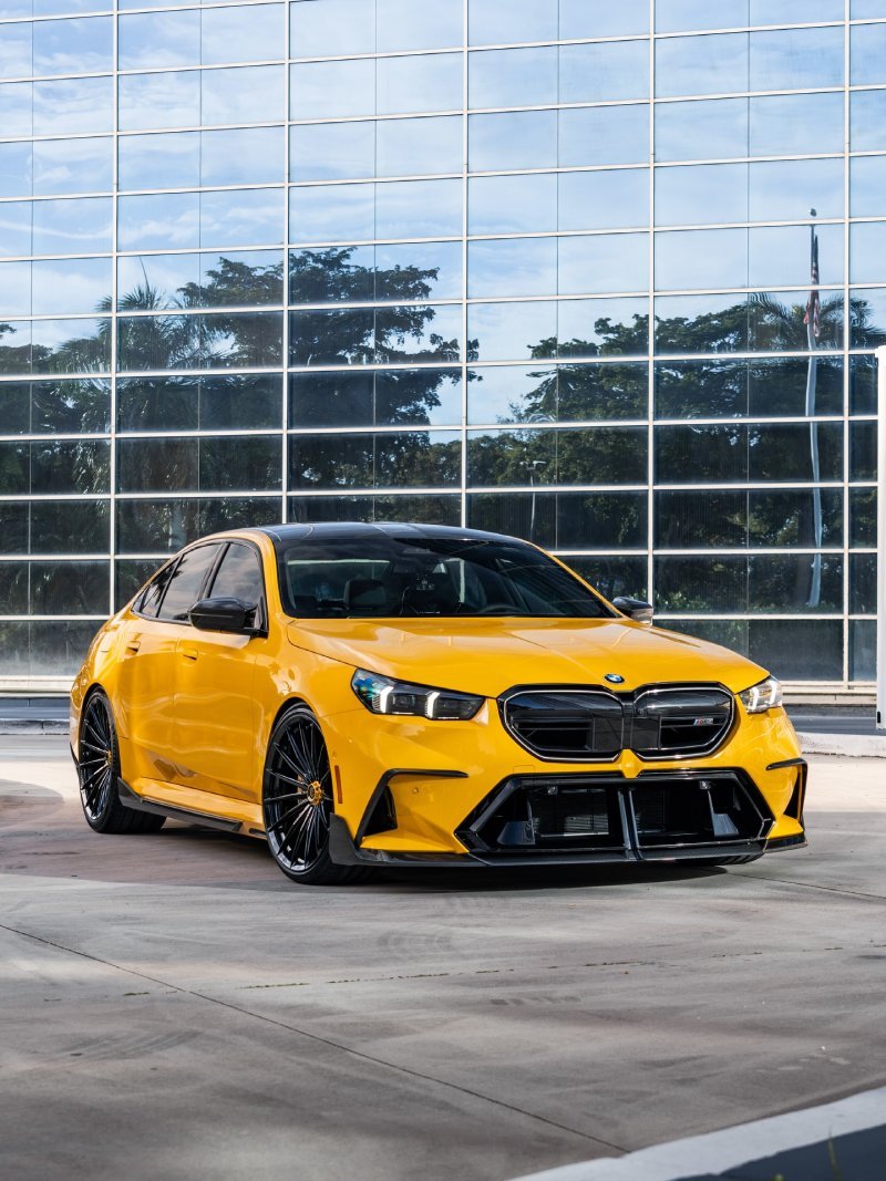 BMW M5 G90 amarelo rebaixado visto de frente em ângulo, com rodas Vossen aro 22