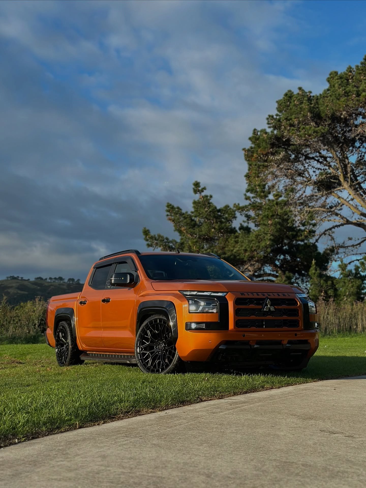 Mitsubishi L200 rebaixada laranja com rodas aro 22 pretas