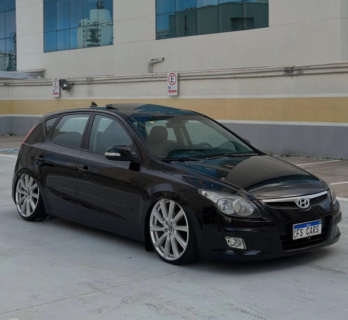 Hyundai i30 preto rebaixado com suspensão a ar, perfil lateral com rodas aro 20 prateadas