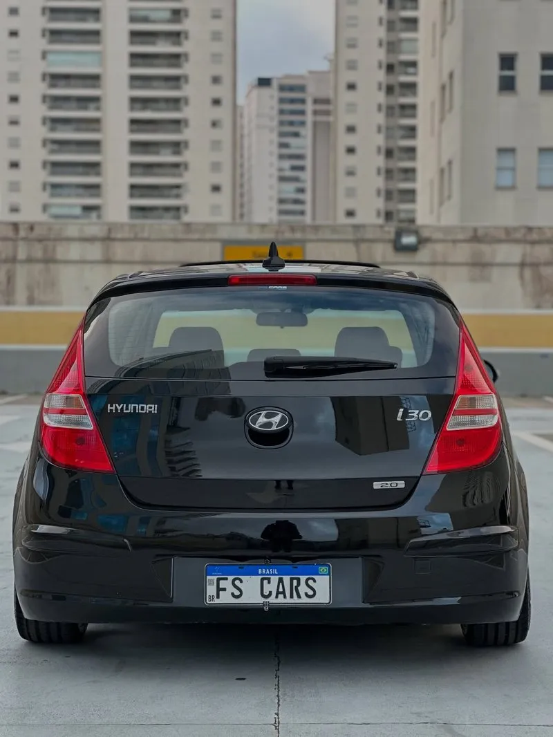 Traseira do Hyundai i30 rebaixado preto com rodas grandes e placa personalizada da FS CARS