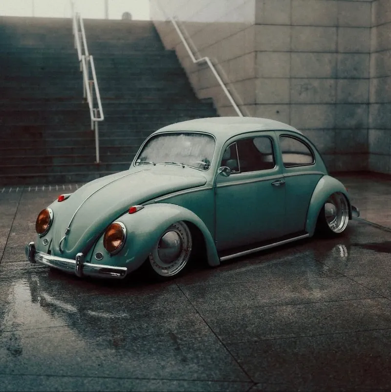 Fusca rebaixado de frente em ambiente urbano molhado