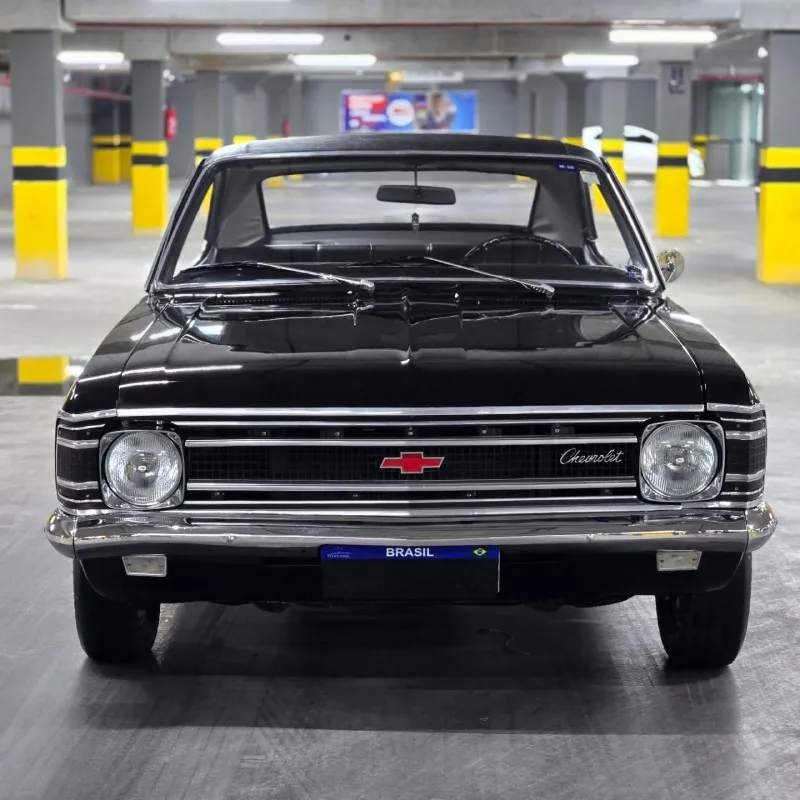 Frente do Chevrolet Opala 1972 preto, grade com gravata Chevrolet e para-choques cromados