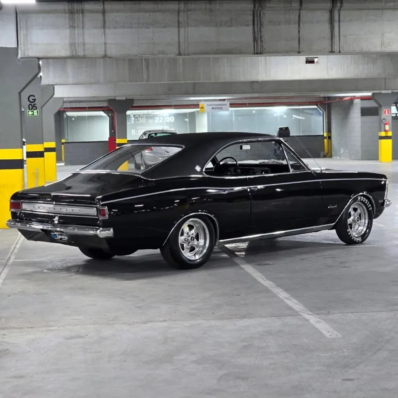 Chevrolet Opala 1972 preto rebaixado em garagem, visão ampla lateral