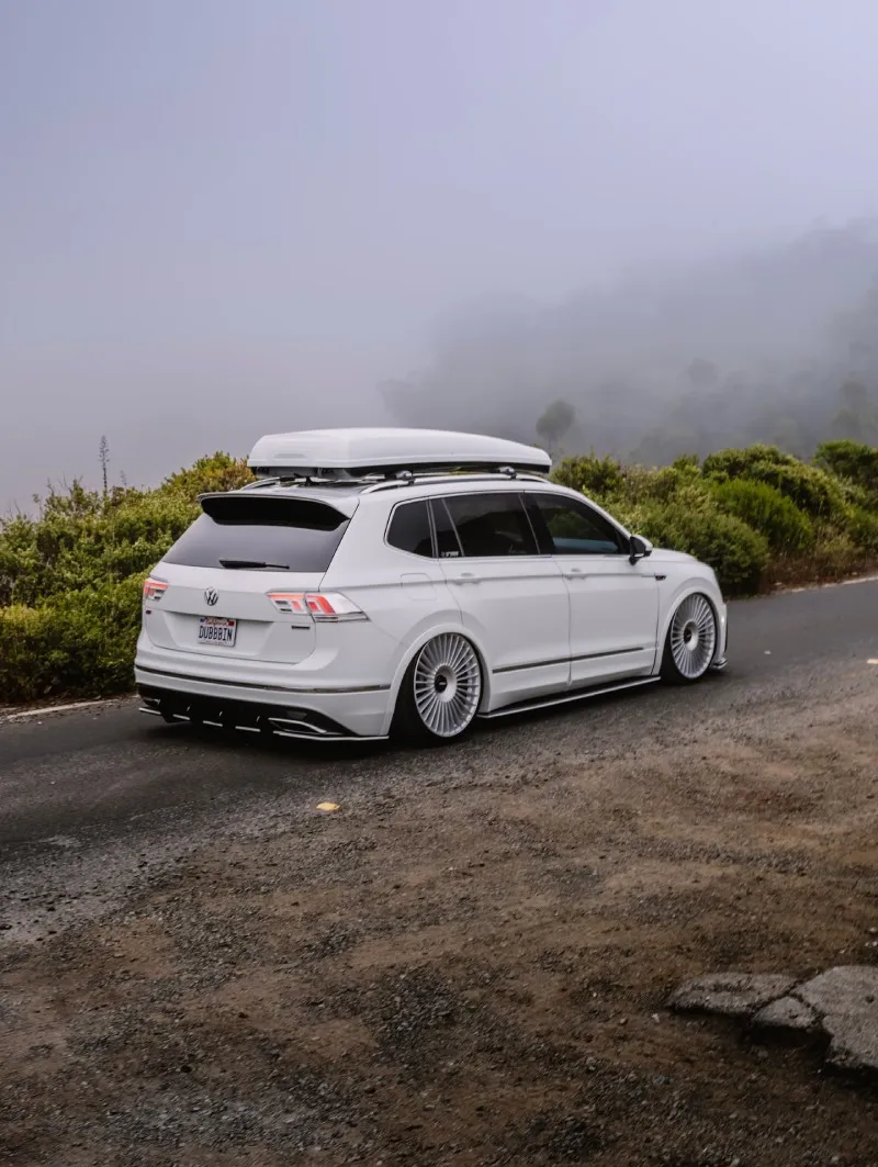 VW Tiguan rebaixada em três-quartos traseiro rodando em estrada