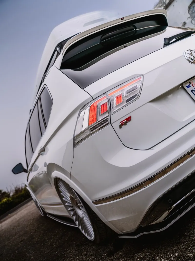 Detalhe de traseira da VW Tiguan R-Line rebaixada com lanternas acesas