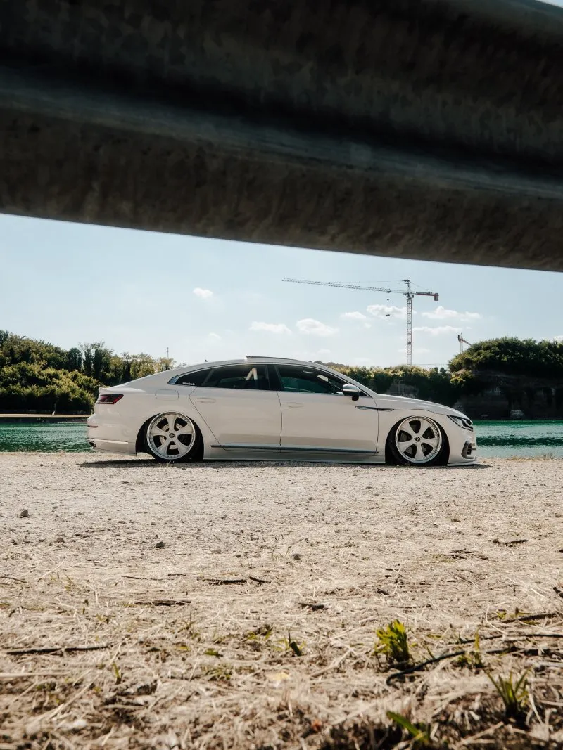 Arteon rebaixado branco — traseira 3/4 Arteon R-Line branco rebaixado traseira três-quartos em ambiente externo