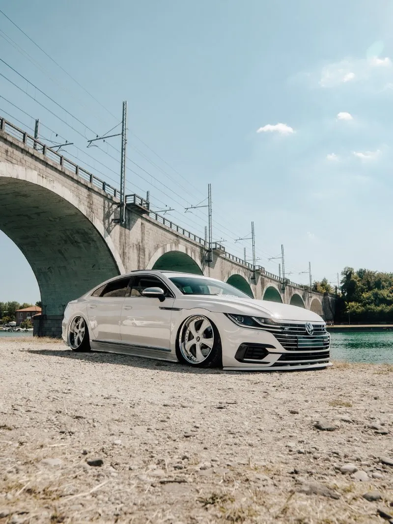 Volkswagen Arteon rebaixado branco Volkswagen Arteon branco rebaixado perfil baixo em local com ponte ao fundo