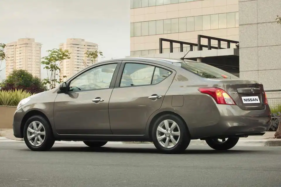 Nissan Versa 2014 usado Nissan Versa vermelho de primeira geração visto de perfil